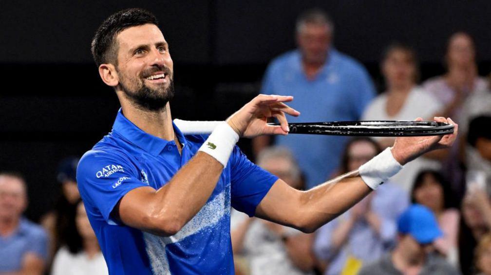 alt="Towering American Opelka Overpowers Novak Djokovic in Brisbane"